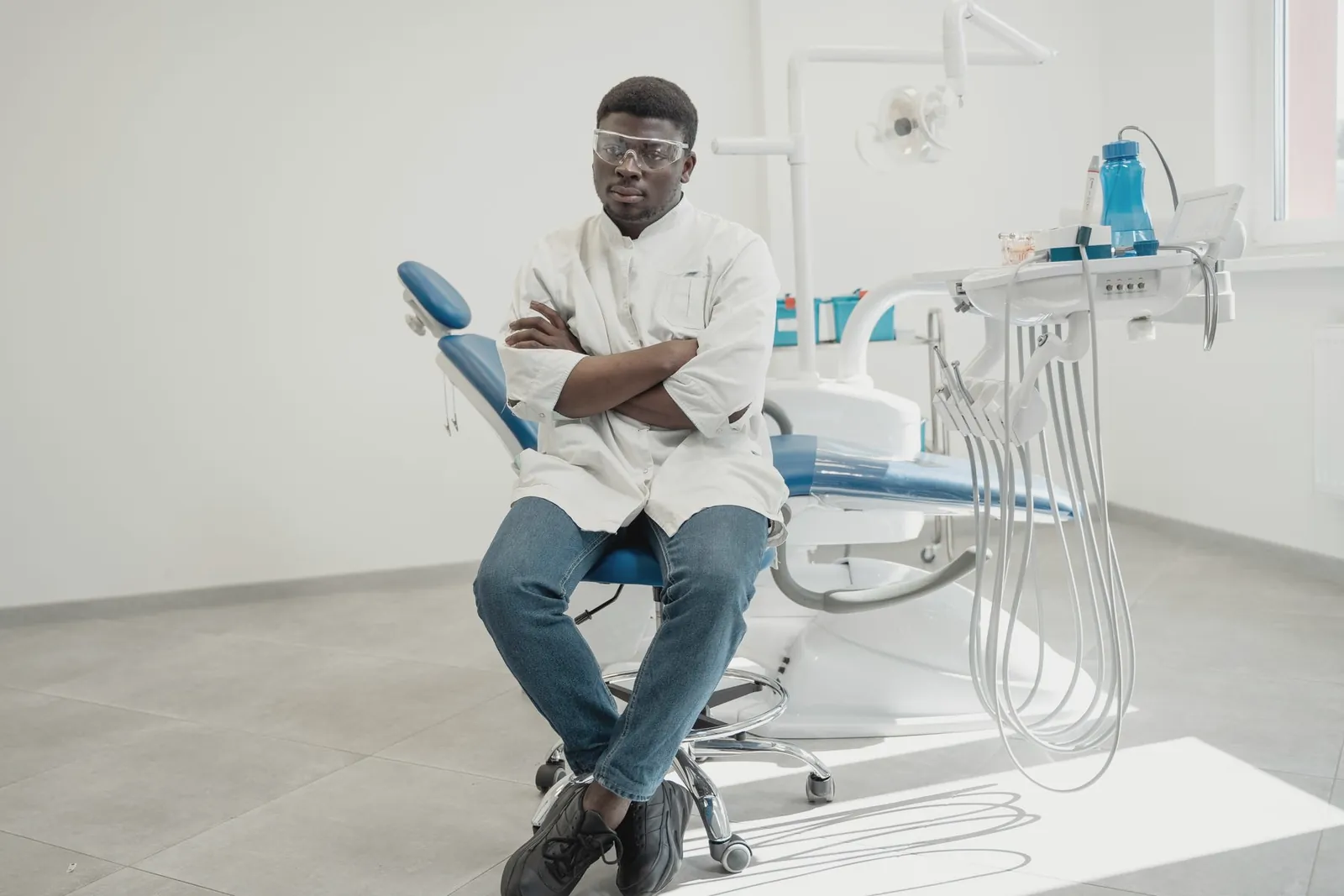Dentiste assis à côté d’un fauteuil vide, en attente de patients